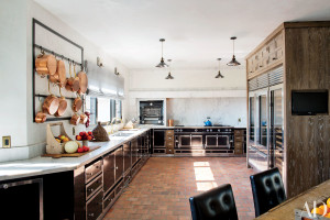 Ellen Pompeo’s dream kitchen in Los Angeles, designed by Martyn Lawrence Bullard, includes a La Cornue range, oven, and cabinetry and a Carrara-marble backsplash. The pendant lights are from Treillage, the custom-made pot rack is by Bullard, and the sink and fittings are by Waterworks.