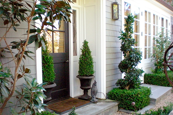 A pair of boxwoods in planters on either side of the front door is a traditional, tidy welcome.