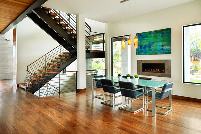 The formal dining room lights came with the owners—a previous gift from husband to wife. The table is Room & Board and the abstract artwork above the fireplace is by Koen Lybaert.