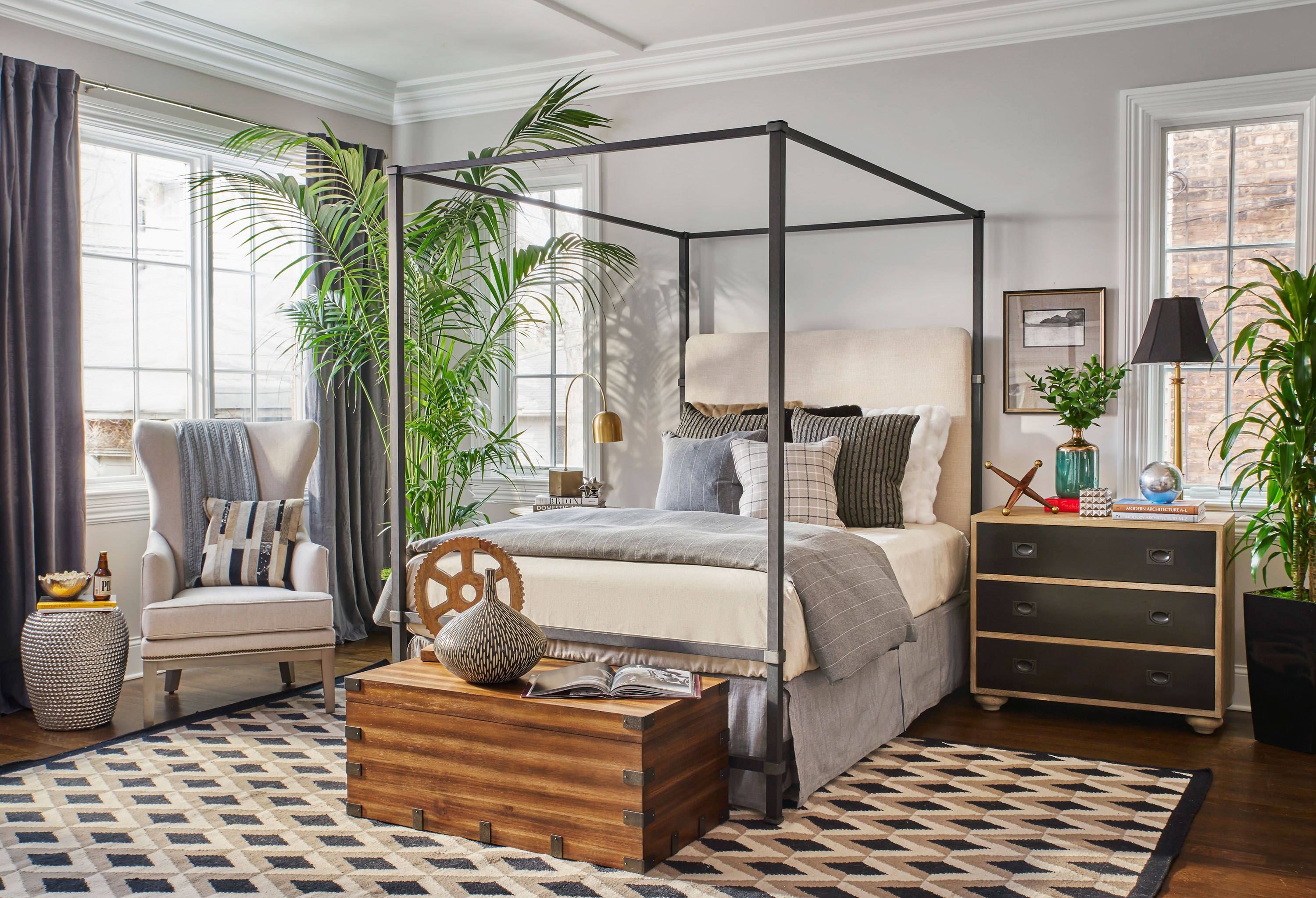 “Matching furniture sets can be boring and unimaginative. I intentionally mismatch pieces for visual diversity. In this bedroom, I balanced a heavy bedside table with a tall tree and accent chair for symmetry. The high ceilings were prone to shrink most beds, but we chose a tall iron canopy bed that fit the space perfectly.”