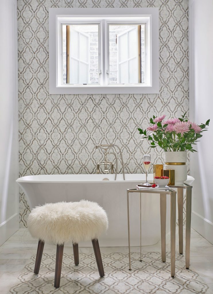 “Bathrooms often feel cold and disconnected from the public rooms. Add furniture such as an accent table, a cozy chair, or an ottoman to bring warmth and comfort.”