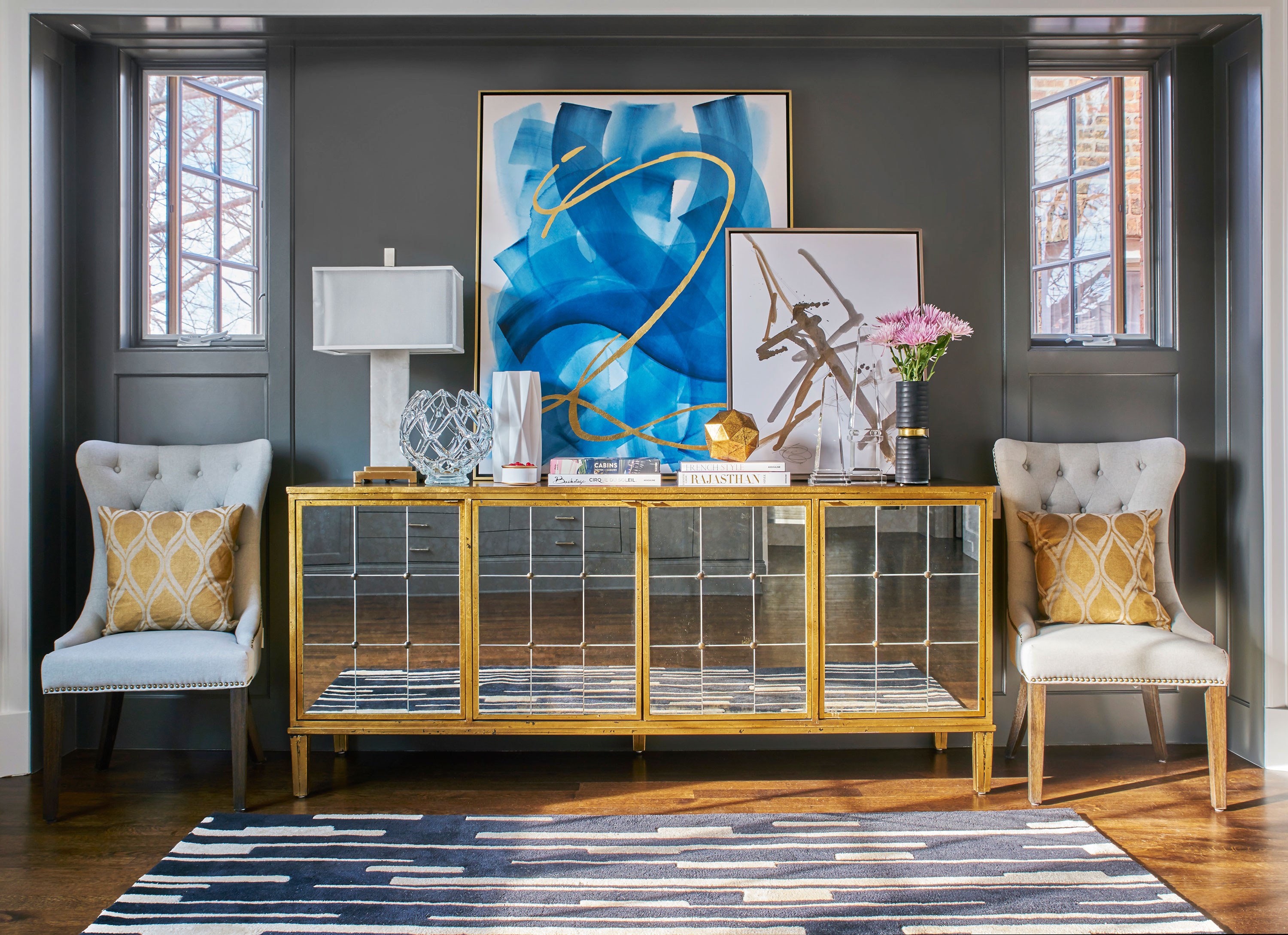 “In a dark space, try integrating reflective furniture and accessories. Next, mix in light colored art, upholstery pieces, and rugs. Everything will feel light, bright, and more spacious.”